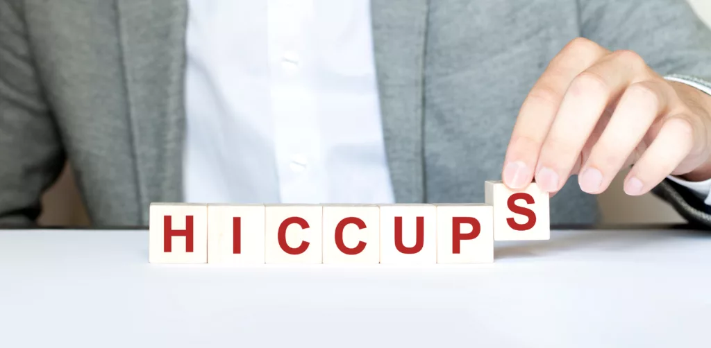 Word HICCUPS made with wood building blocks